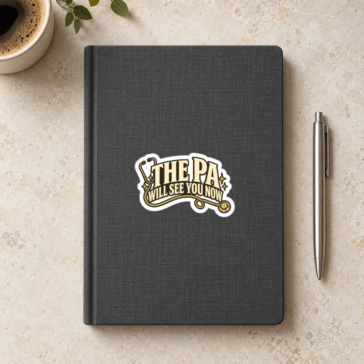 The PA Will See You Now Sticker in the 3 × 3 inch size shown on a charcoal notebook in an illustrative lifestyle mockup