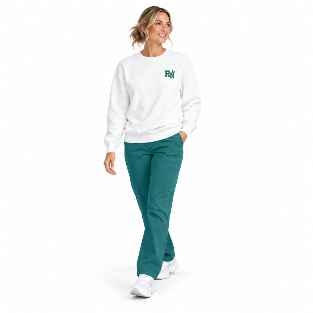 Nurse walking in a white RN holly embroidered sweatshirt with teal scrub pants on a white background