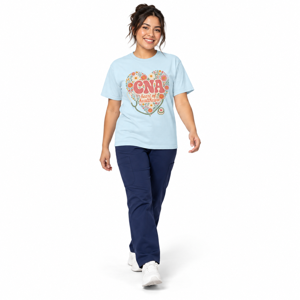 Healthcare professional walking in a Chambray CNA Heart of Healthcare tee with scrub pants on white