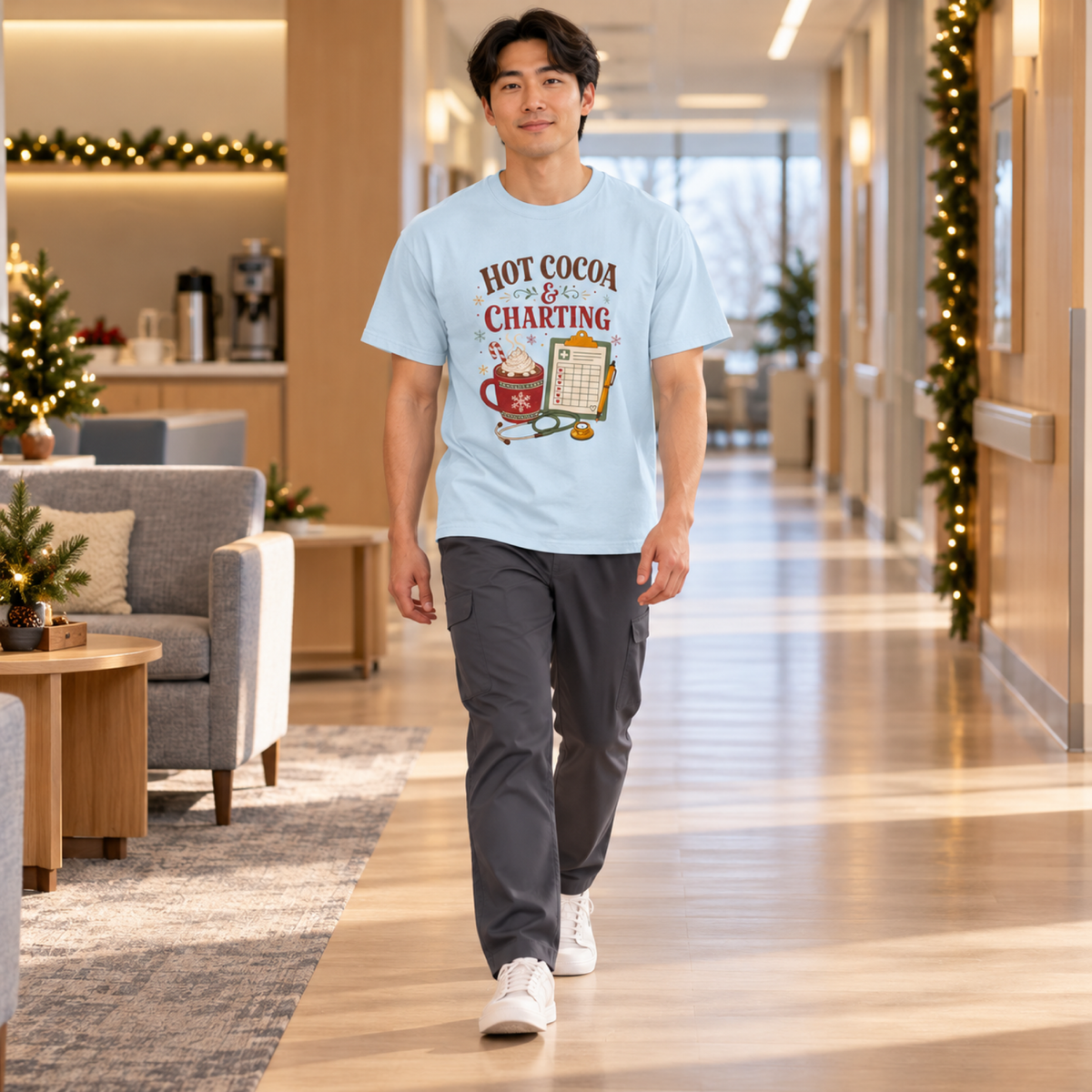 Healthcare model wearing the Chambray Hot Cocoa and Charting tee with charcoal scrub trousers in a festive staff lounge