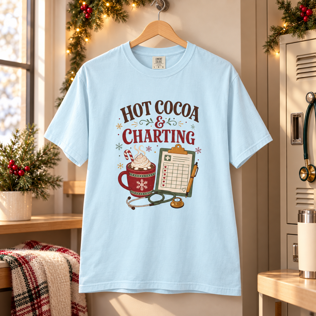 Chambray blue Hot Cocoa and Charting shirt on a hanger in a cozy holiday medical staff nook