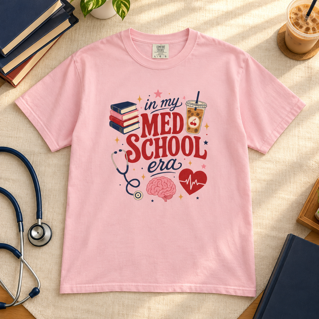 Blossom pink In My Med School Era tee flat lay on a warm medical study desk