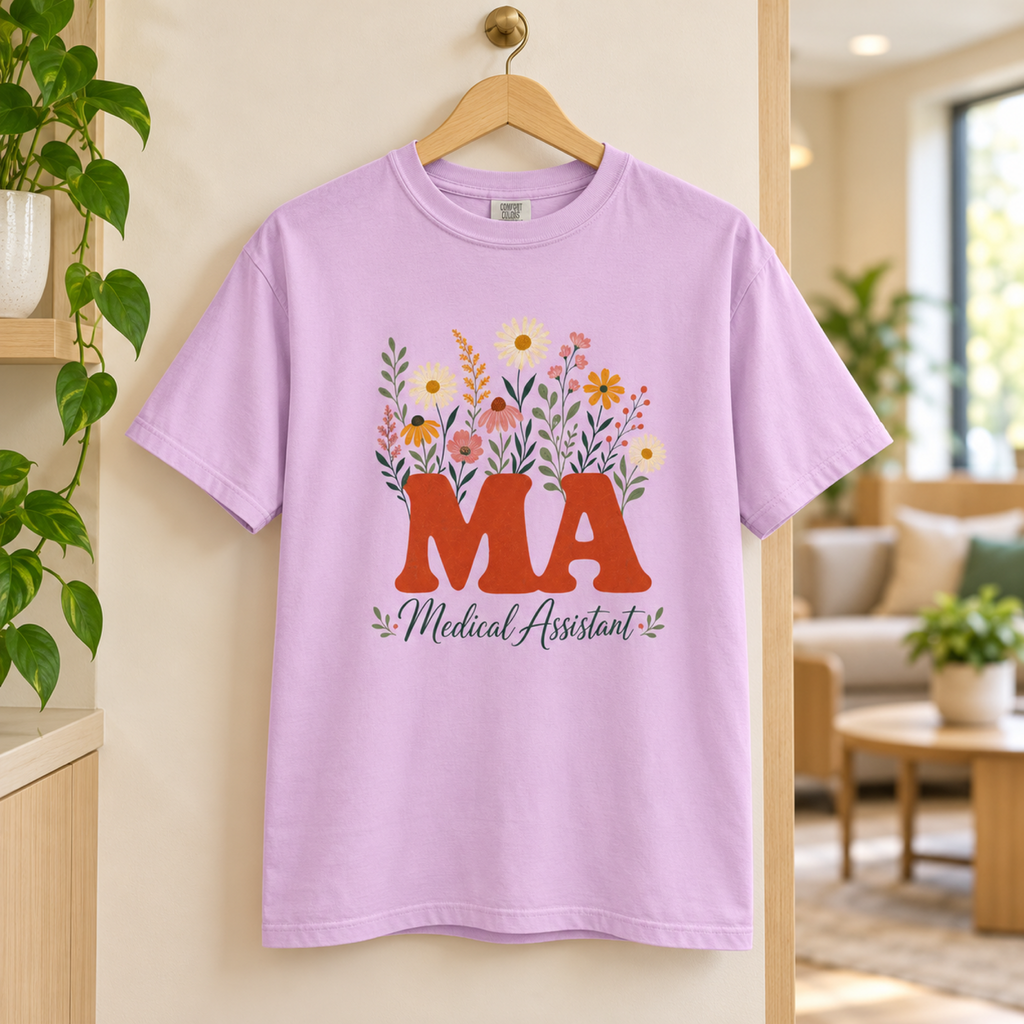 Orchid purple floral Medical Assistant MA tee on a wooden hanger in a warm clinic staff lounge
