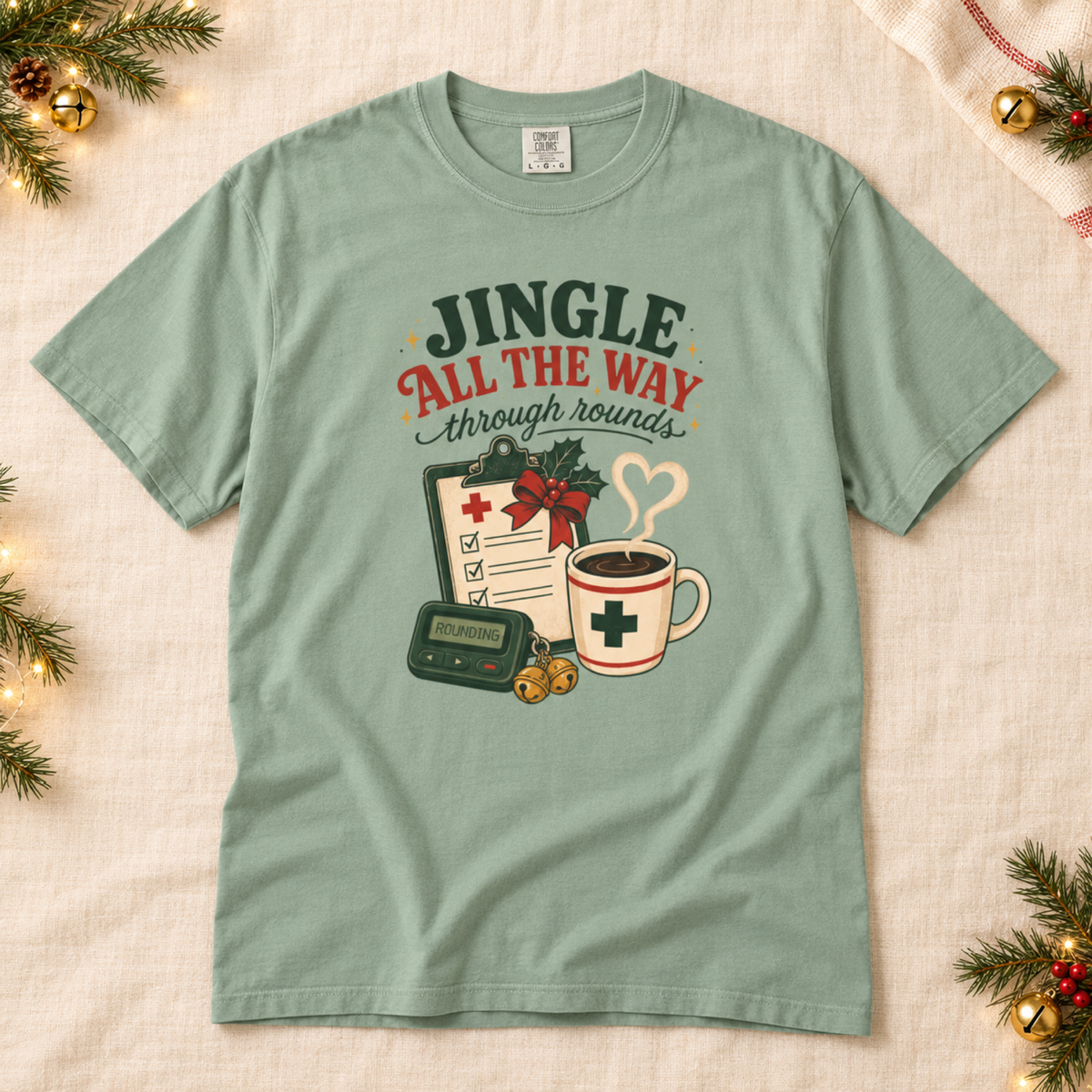 Bay green Jingle All the Way Through Rounds Christmas tee flat lay on cream linen with festive pine and bells