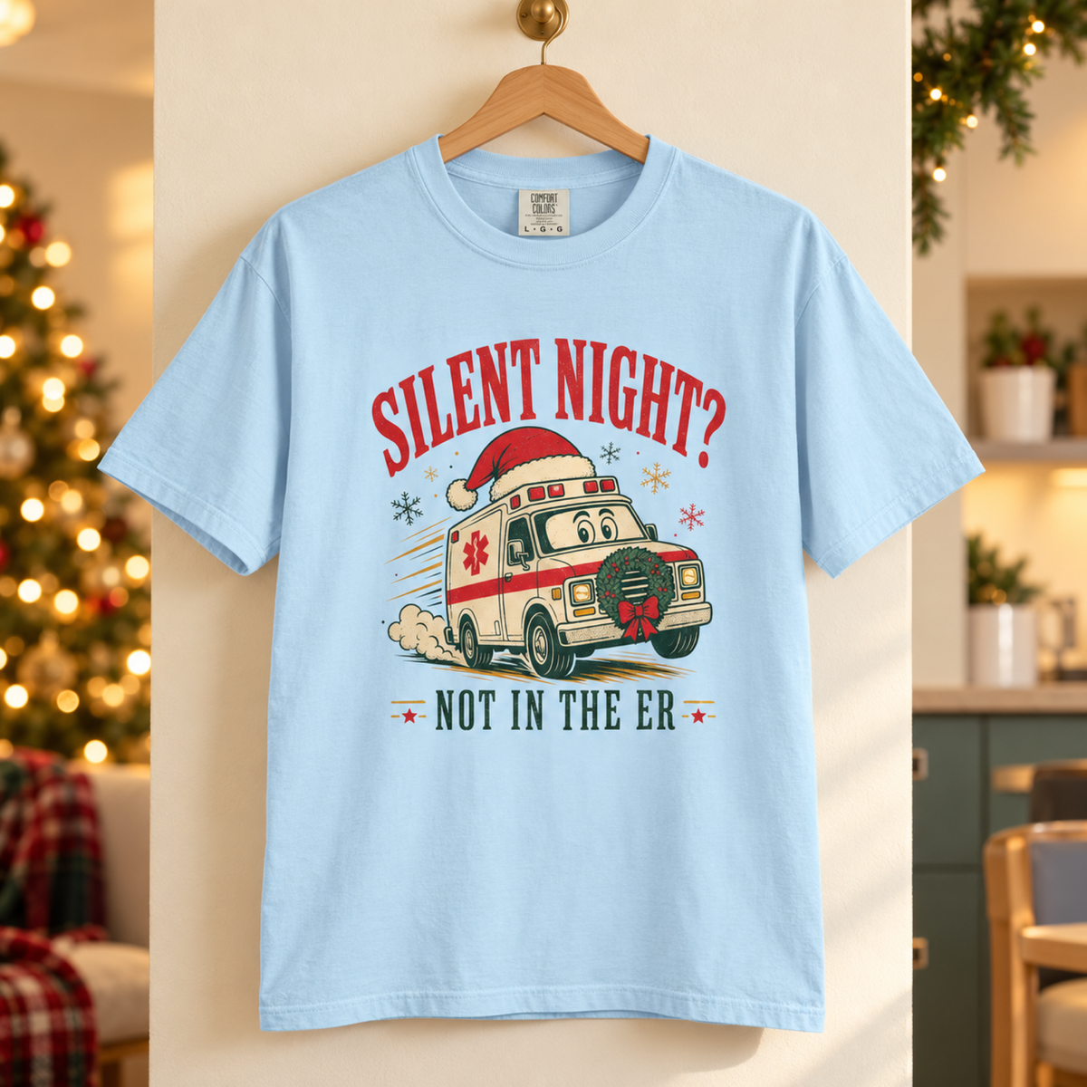 Chambray blue Silent Night Not in the ER Christmas ambulance tee on a hanger in a warm festive staff lounge