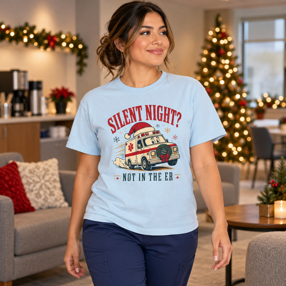 Healthcare professional wearing Chambray blue Silent Night Not in the ER tee with navy scrub trousers in a festive staff lounge