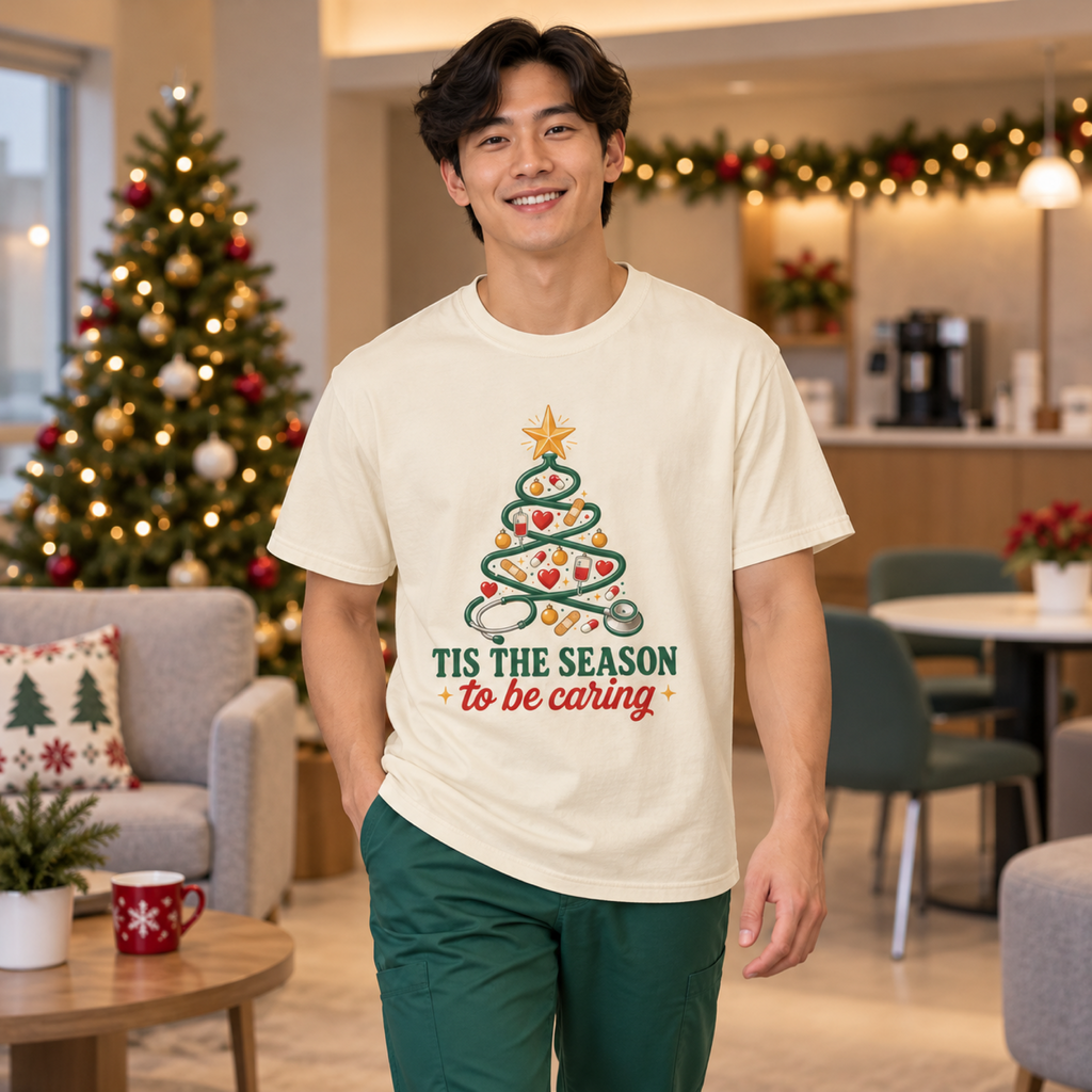 Healthcare professional wearing Ivory Tis the Season to Be Caring tee with green scrub trousers in a festive medical staff lounge