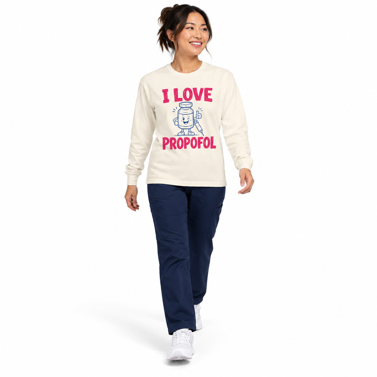 Healthcare professional walking in Ivory I Love Propofol long sleeve shirt with navy scrubs on white