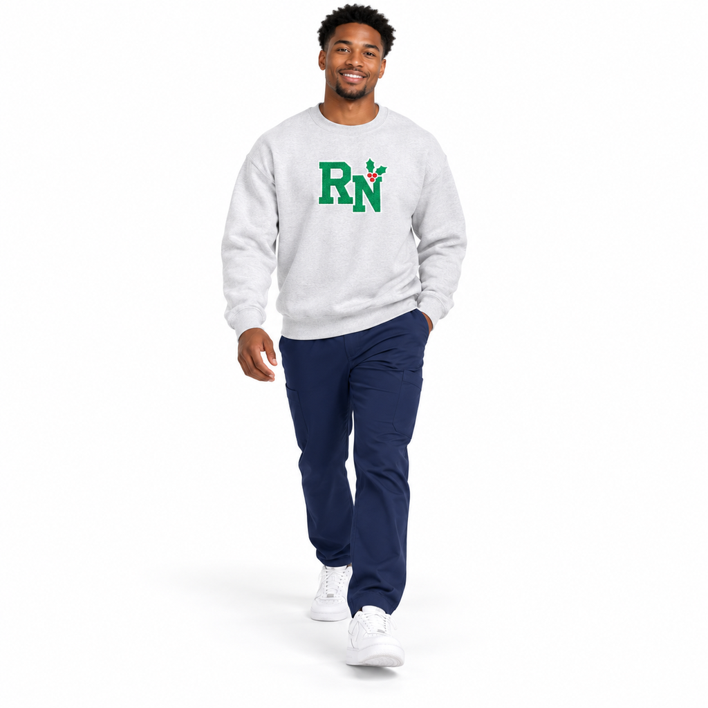 Healthcare professional walking in Ash RN holly center embroidered sweatshirt with navy scrub pants against white