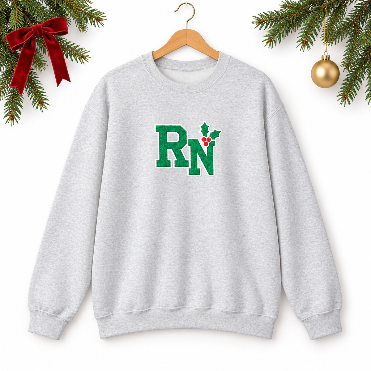 Ash RN holly embroidered sweatshirt on hanger with Christmas greenery on white