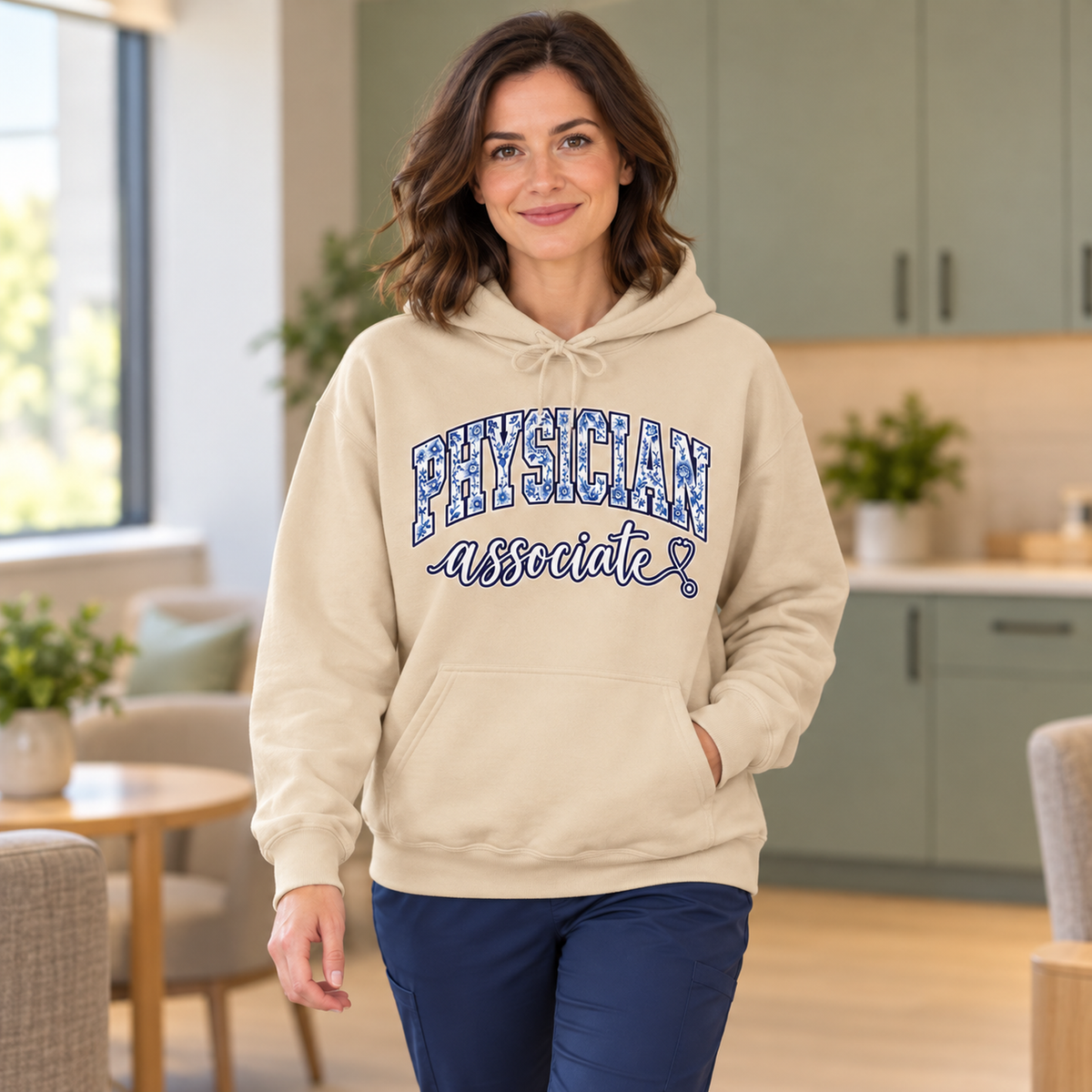 Physician Associate Floral Varsity Hoodie in Sand — model in warm medical setting