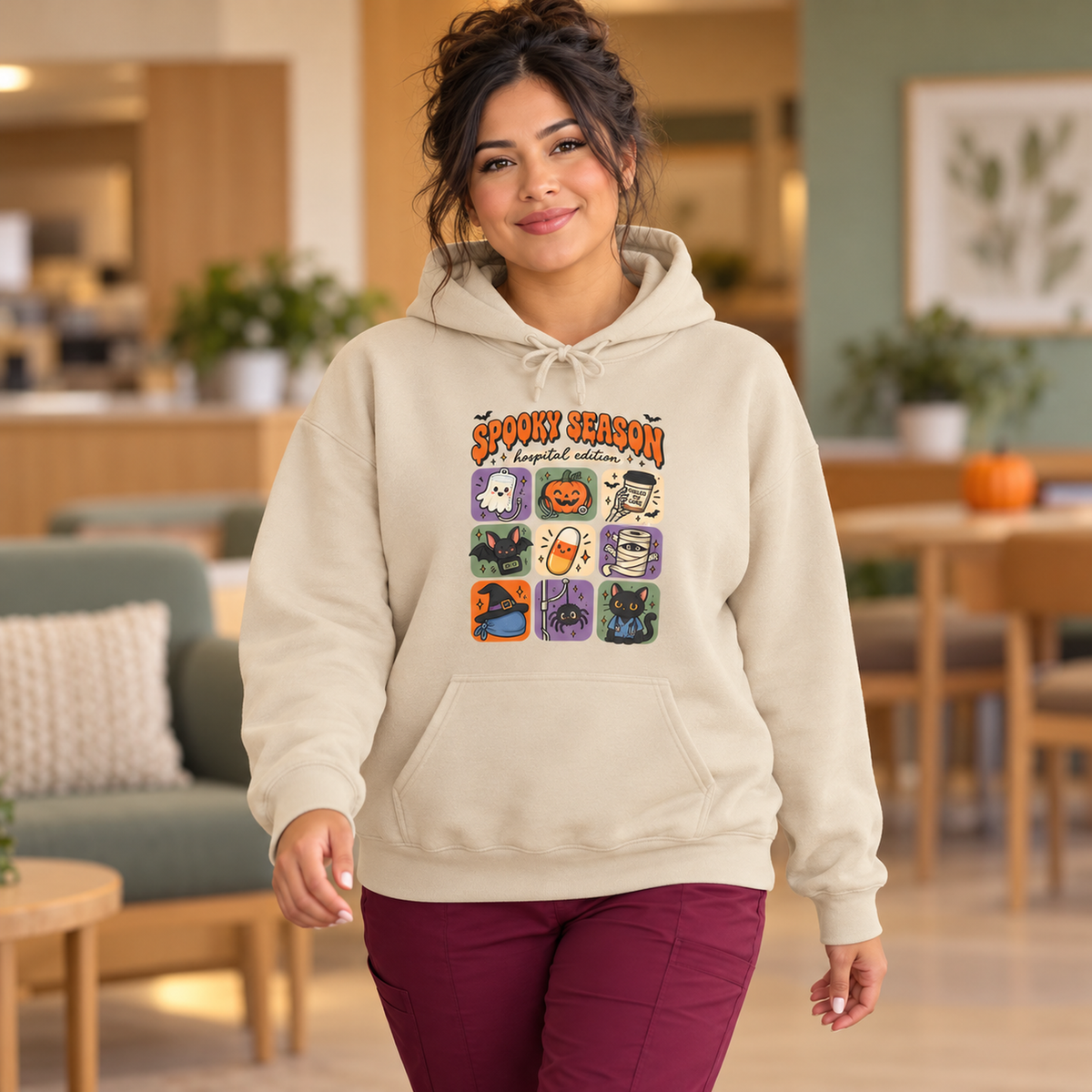 Spooky Season Hospital Edition Hoodie in Sand — model in warm medical setting